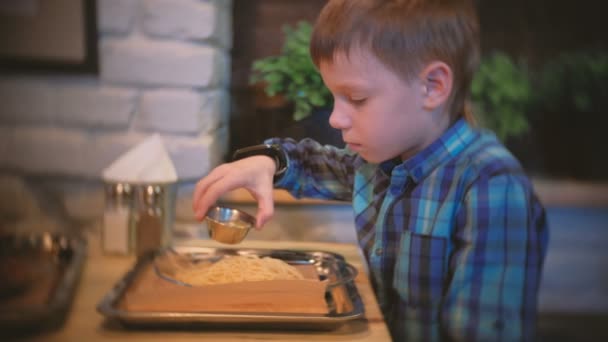 Мальчик наливает масло спагетти. Вид сбоку . — стоковое видео