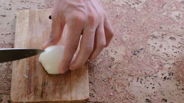 Man gently cuts the onion into small pieces. Mans hands close-up. — Stock Video