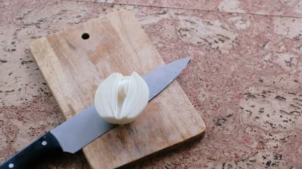 Messer und Zwiebel auf einem Holzbrett. — Stockvideo