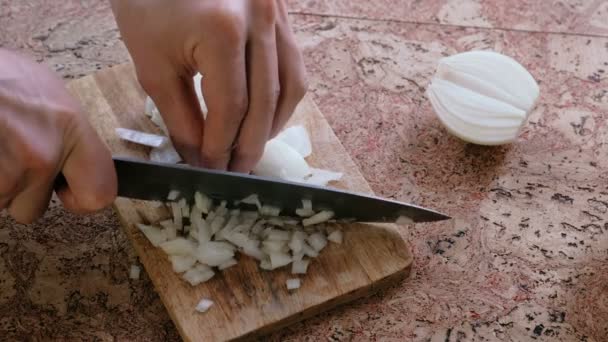 Man gently cuts the onion into small pieces. Mans hands close-up. — Stock Video