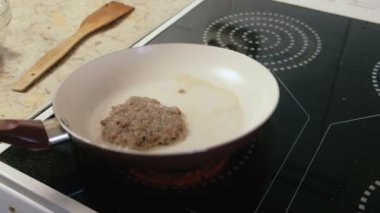 Adam üzerinde pan pirzola Burger için kızartma. Eller yakın çekim.