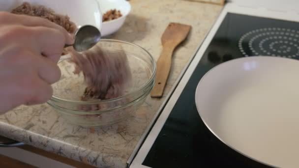 Чоловік змішує фарш і смажені шматочки бекону в мисці. Кухонні котлети для бургерів . — стокове відео