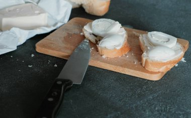 Ekmek, tereyağı ve yumurta ahşap tahta siyah arka plan üzerinde closeup sandviç. Bir sandviç yapmak.