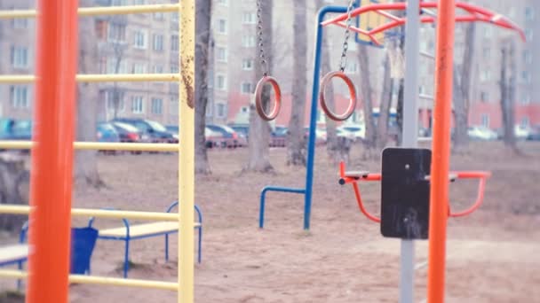 Gymnastiek ringen swing in de binnenplaats van het dorpshuis op de speelplaats. — Stockvideo