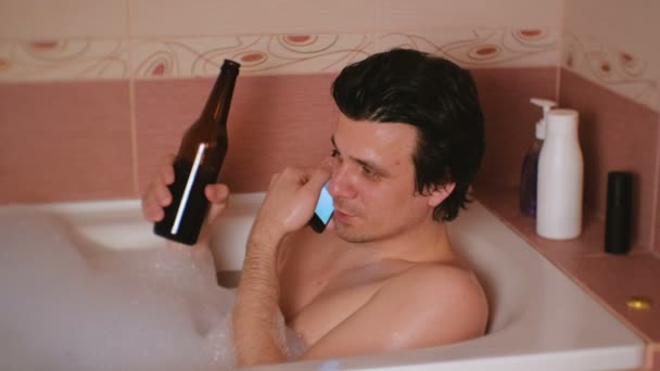 Fiatal ember vesz egy fürdőt, hab, beszél a mobiltelefon. — Stock videók