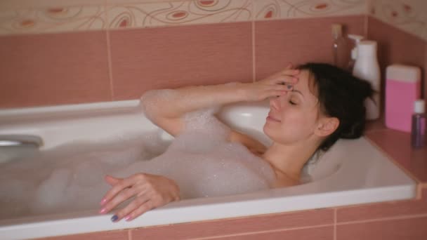 Ung vacker kvinna vila medan du tar ett bad med skum. — Stockvideo