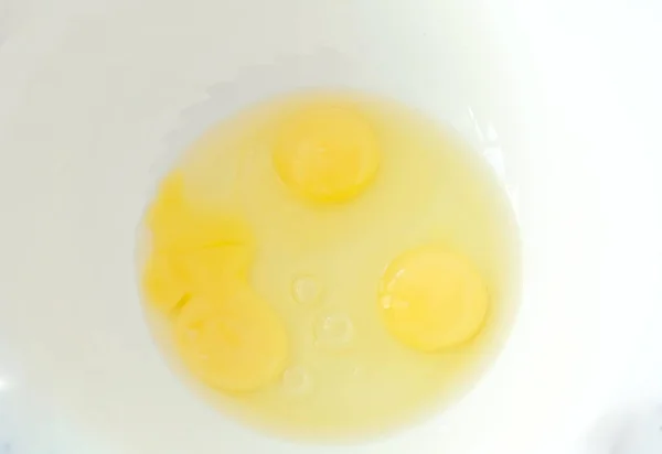 Закрыть три свежих яйца в белой миске . — стоковое фото