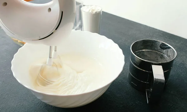 Close-up womans hands with a mixer whisk egg with sugar in a bowl. Pai apel masak . — Stok Foto