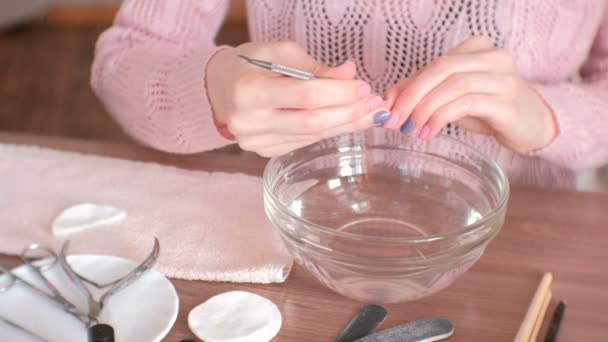 Cuticle remover. Vrouw maakt manicure zelf. Close-up handen. — Stockvideo