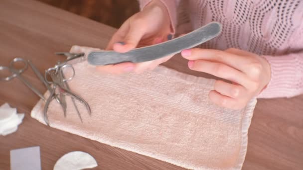 Woman filings nails nail file. Close-up hands. Tools on the table. — Stock Video