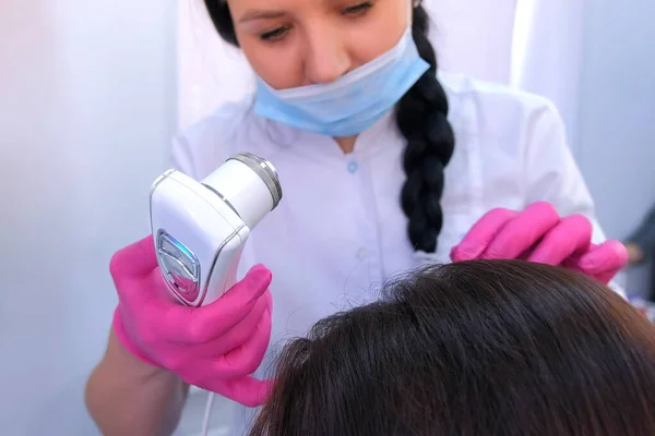Trichologist examina cabelos de paciente mulher usando tricoscopia de computador na clínica . — Fotografia de Stock