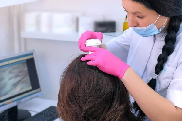 Trikoloğum klinikte bilgisayar trikoskopisi kullanarak kadın hasta kıllarını inceliyor.. — Stok fotoğraf