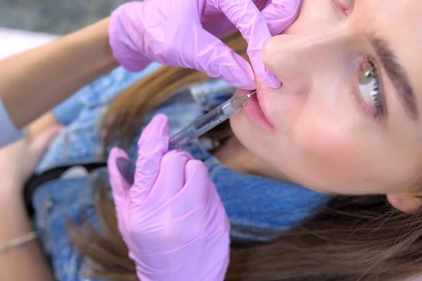 Инъекции в женские губы, чтобы сделать объем и форму коррекции в клинике красоты . — стоковое фото