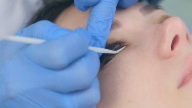 Güzellik uzmanı kirpikleri iğneyle kıvırıyor, kirpikleri kaldırıyor..