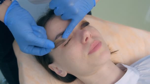 Ascensore procedura laminazione ciglia in clinica di bellezza per giovane donna, primo piano viso. — Video Stock