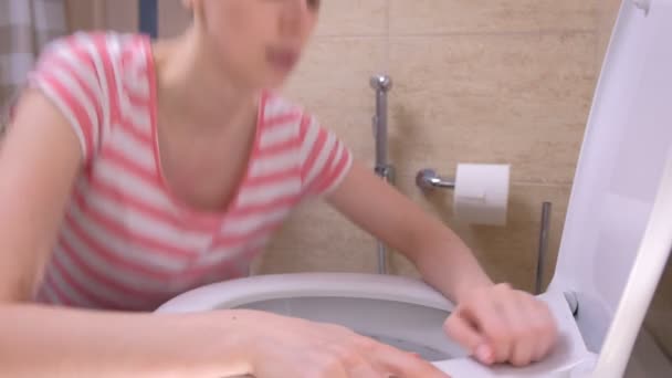 Jeune femme malade va aux toilettes pour vomir assis sur le sol à la maison, symptôme de grippe . — Video
