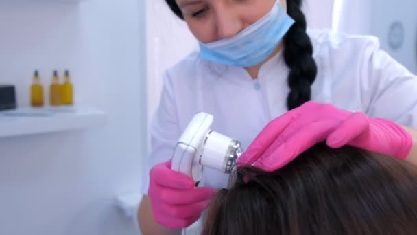 Trichologist examines woman patient hairs using computer trichoscopy in clinic. — Stock Video