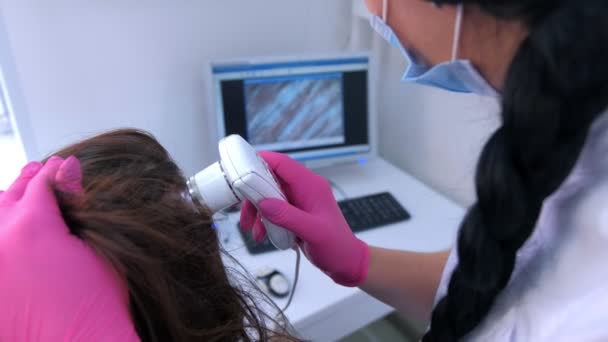 Trichologist examina cabelos de paciente mulher usando tricoscopia de computador na clínica . — Vídeo de Stock