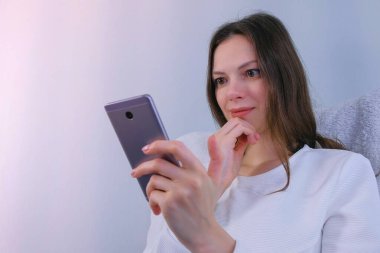 Kadın cep telefonu komik video izler.