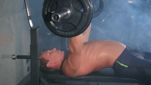 Professionele atletische man bodybuilder doen lange halter borst oefening op bank. — Stockvideo