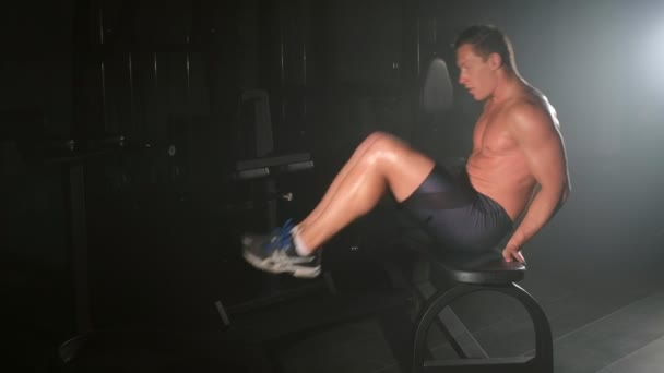 Bodybuilder jeune homme est la formation de son abdomen sur le banc, abdos séance d'entraînement dans la salle de gym . — Video