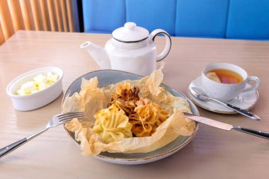 Julienne çay ve tereyağı ile baker kağıt üzerinde bir tabakta servis hamur içinde pişmiş. Yan görünüm.