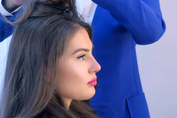 Rosto da jovem mulher no salão de beleza no penteado com cabeleireiro, vista lateral . — Fotografia de Stock