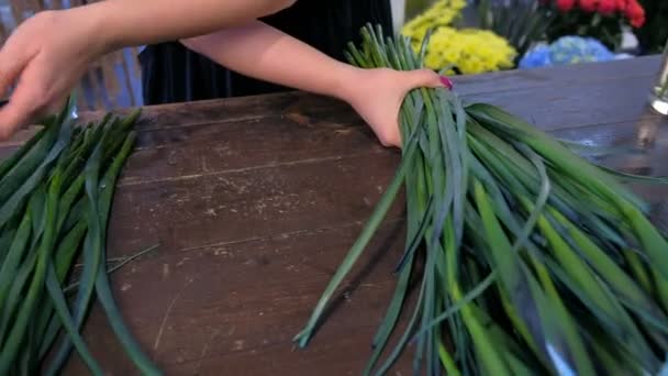 Квіткова жінка робить букет з квітів синьої іриси на столі для продажу в магазині . — стокове відео