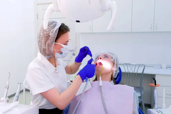 Dentiste guérit les dents de la jeune femme dans la clinique de stomatologie, procédure de traitement . — Photo