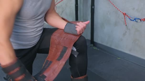 Sportsman sätter på Fixatorer på sidan förbereder sig för Myofascial stretching i gymmet. — Stockvideo