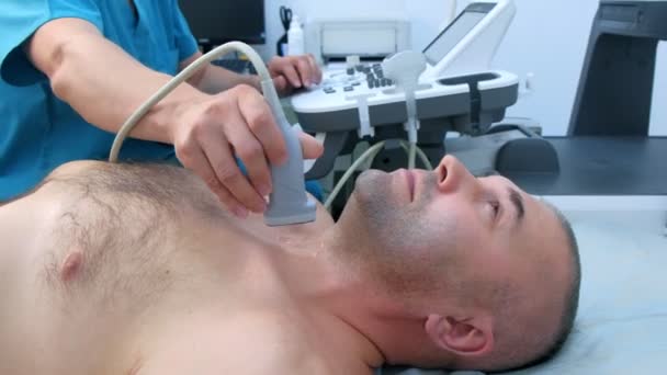 Homem médico examinando paciente glândula tireóide usando scanner de ultra-som, vista lateral . — Vídeo de Stock