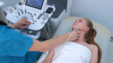 Hasta muayene eden erkek doktor kadın tiroid bezi ultrason tarayıcısı kullanıyor..