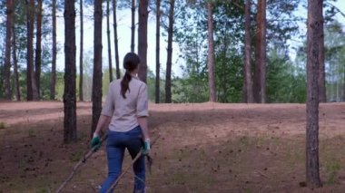 Kadın kesilen ağaçları yakacak odun bulmak için izci kampına taşır..