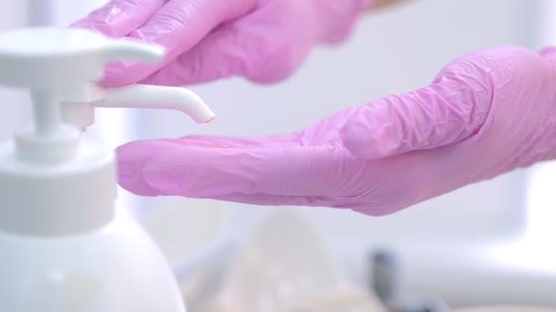 Médecin femme serre le gel du distributeur sur les mains dans des gants, vue rapprochée . — Video