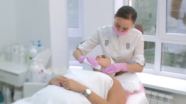 Cosmetoloog het maken van ultrasone gezichtsreiniging procedure om vrouw in kliniek. — Stockvideo