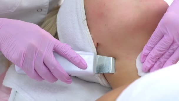 Cosmetoloog maakt ultrasone gezichtsreiniging aan vrouw in kliniek, closeup view. — Stockvideo