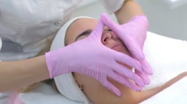 Kozmetik uzmanı müşterilerine krem sürüyor. Kadın yüzü, boyun ve masaj..