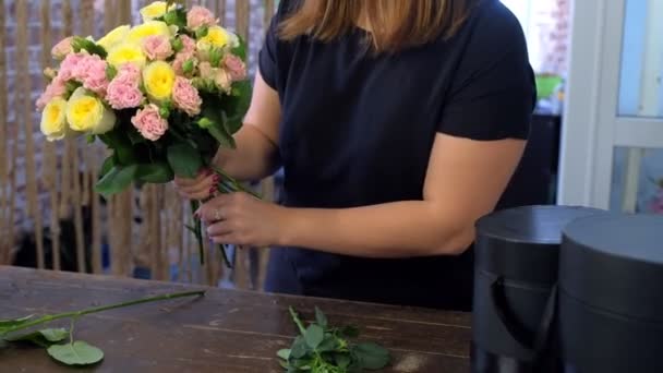 Žena květinářství dělat květiny kytice z různých druhů růží, ruce detailní up. — Stock video