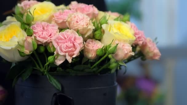 Květinářská žena otáčení kytice růží u stolu v květinářství, detailní pohled. — Stock video