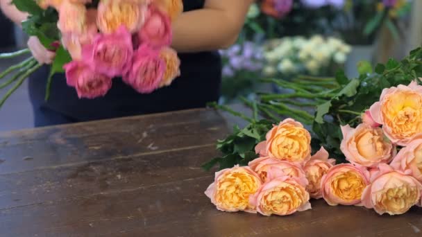 Florista mulher fazendo buquê de peônias rosa e laranja na loja de flores, close-up . — Vídeo de Stock