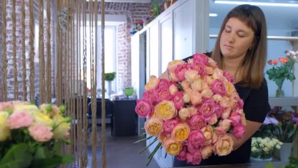 Цветочница делает букет из розовых и апельсиновых пионов в цветочном магазине . — стоковое видео