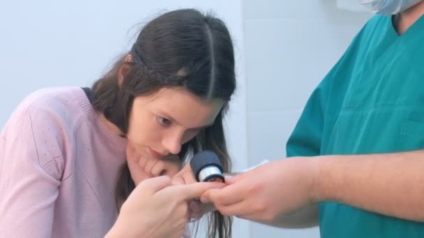 Chirurg en patiënt onderzoeken wrat op vinger met behulp van dermatoscoop Vergrootglas. — Stockvideo