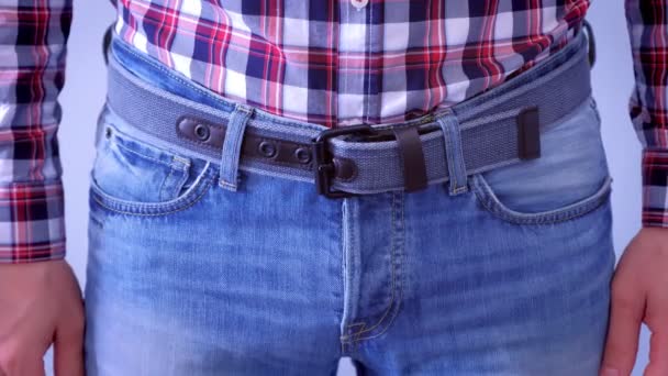 Cintura de hombre en jeans con cinturón moderno y camisa a cuadros . — Vídeos de Stock