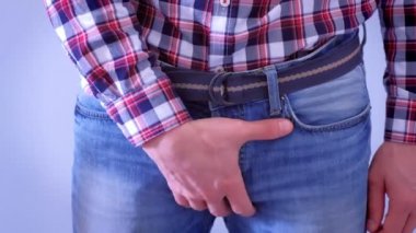 Man corrects his dick in a tight jeans by hand.