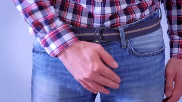 Man is bedekt zichzelf op Kruis in jeans door handen. — Stockvideo