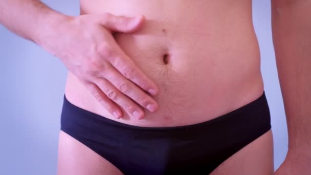 Man in onderbroek raakt zijn slappe vet naakte maag, close-up bekijken. — Stockvideo
