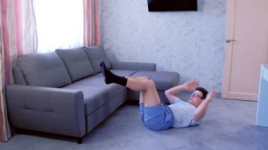Komik nerd adam evde yerde yatan karın crunches egzersiz yapıyor. Spor mizah konsepti.