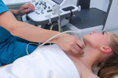 Klinikteki tiroit bezli genç kadın için ultrason taraması yapılıyor..