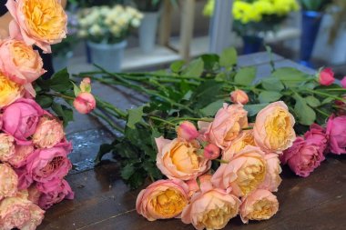 Çiçekçide pembe ve turuncu şakayık buketi yapan çiçekçi kadın, yakın plan..