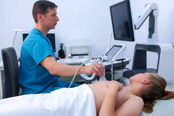 Man doctor making ultrasound diagnostic scanning mammary glands of young woman. — Stock Photo, Image